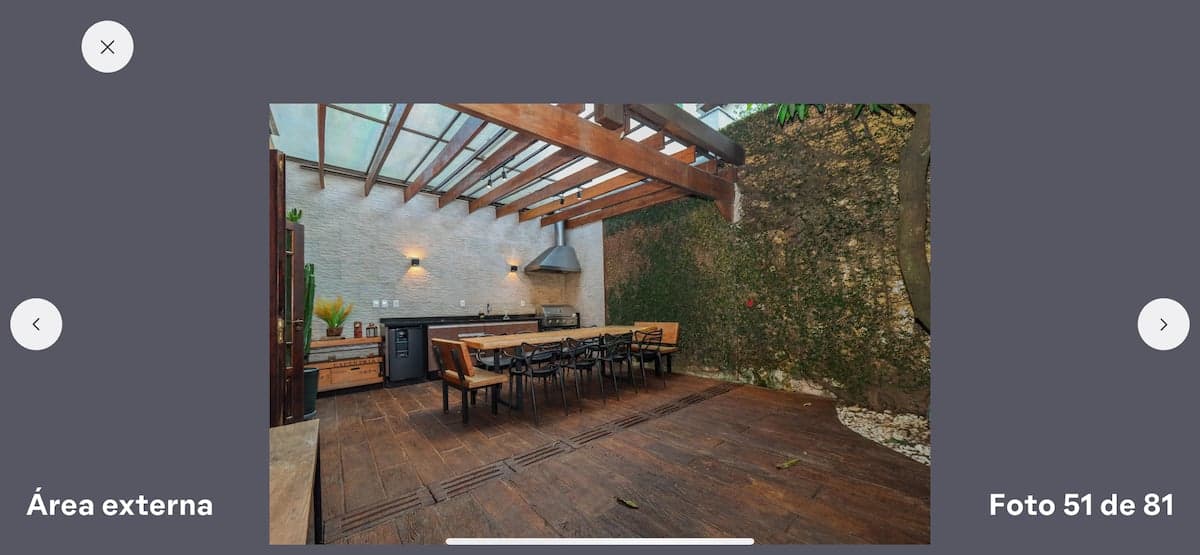 Deck coberto com mesa de madeira e parede de vegetação