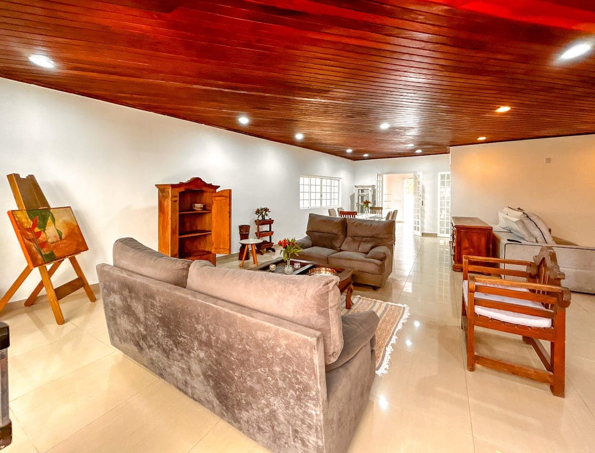 Sala de estar ampla com teto de madeira e sofas
