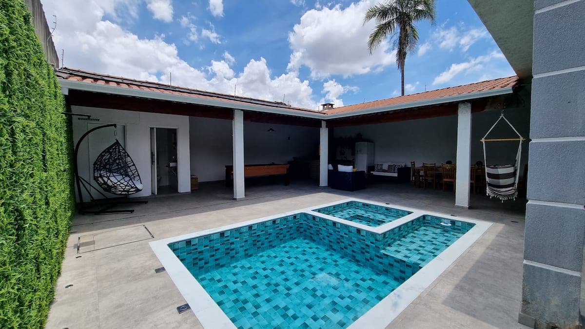 Piscina com prainha e varanda coberta ao fundo