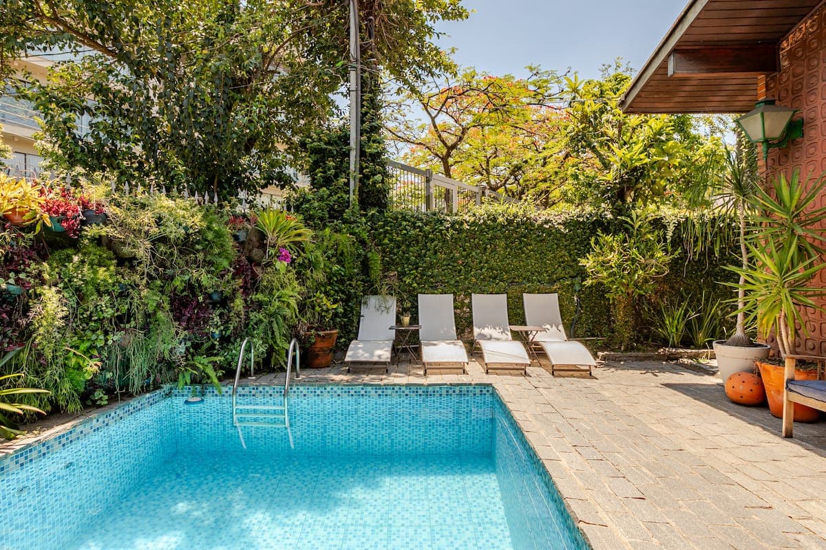 Piscina com espreguicadeiras e jardim vertical ao redor