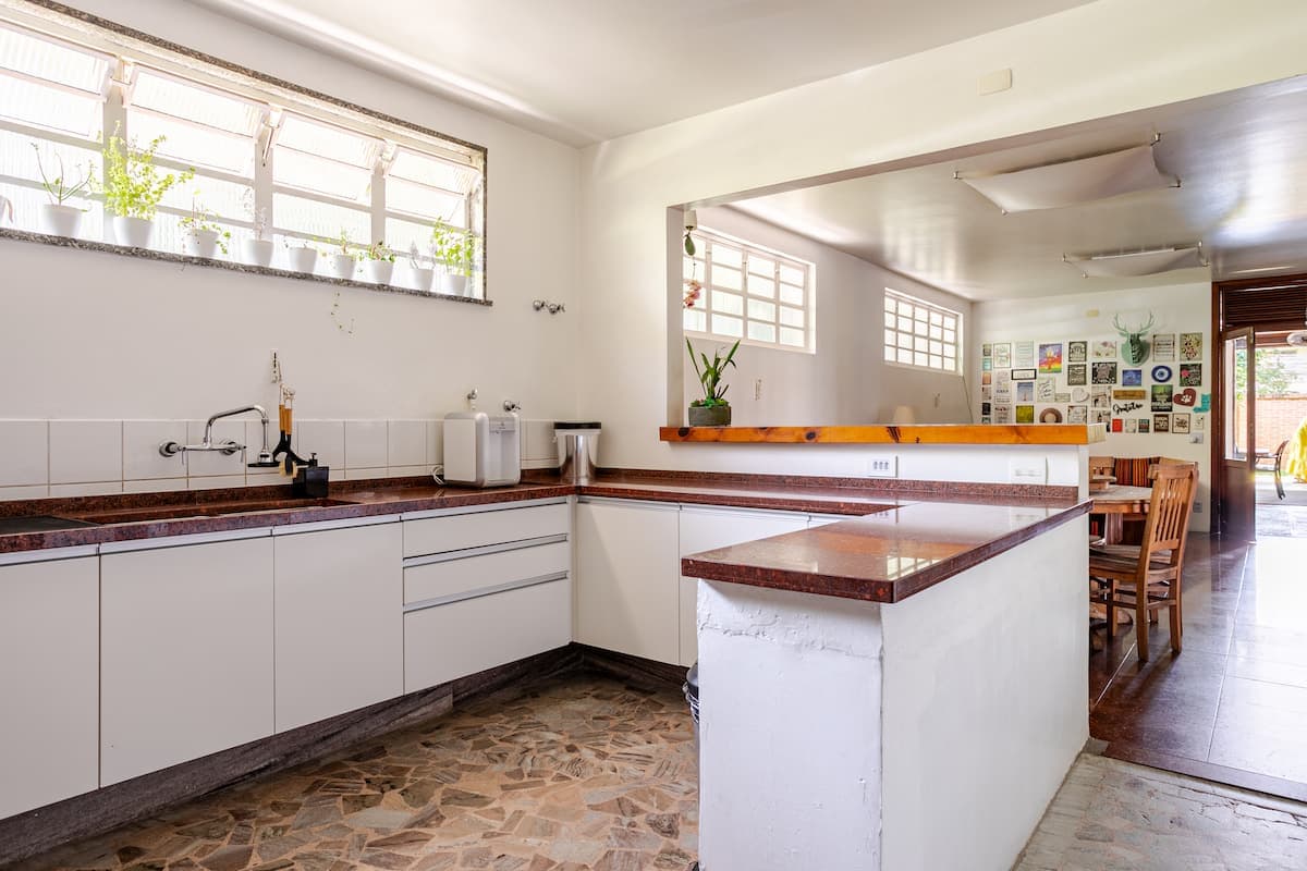 Cozinha com bancada em L e balcao para a sala