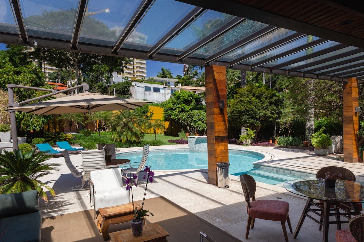 Piscina com pergolado e cadeiras ao redor