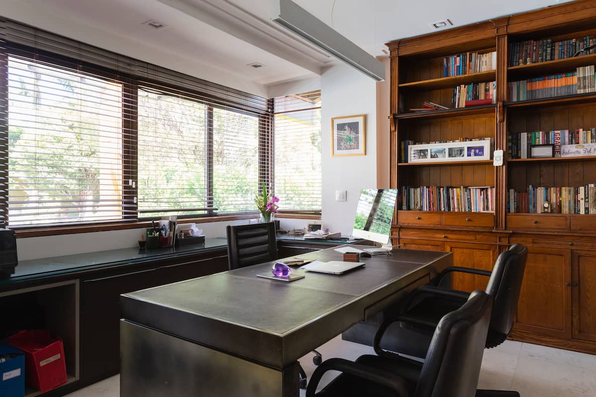 Sala com mesa grande e estante de livros