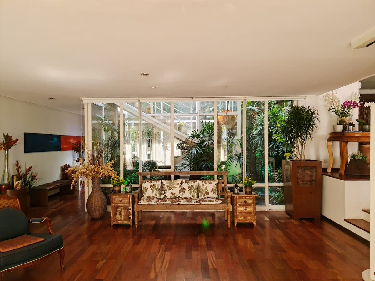Sala com janelas do piso ao teto voltadas para o jardim