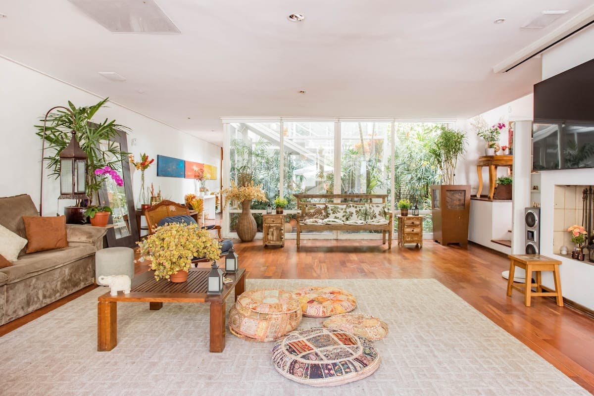 Sala de estar ampla com plantas e saida para a area externa