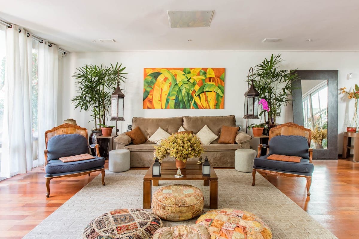 Sala de estar com sofa, poltronas e quadro colorido