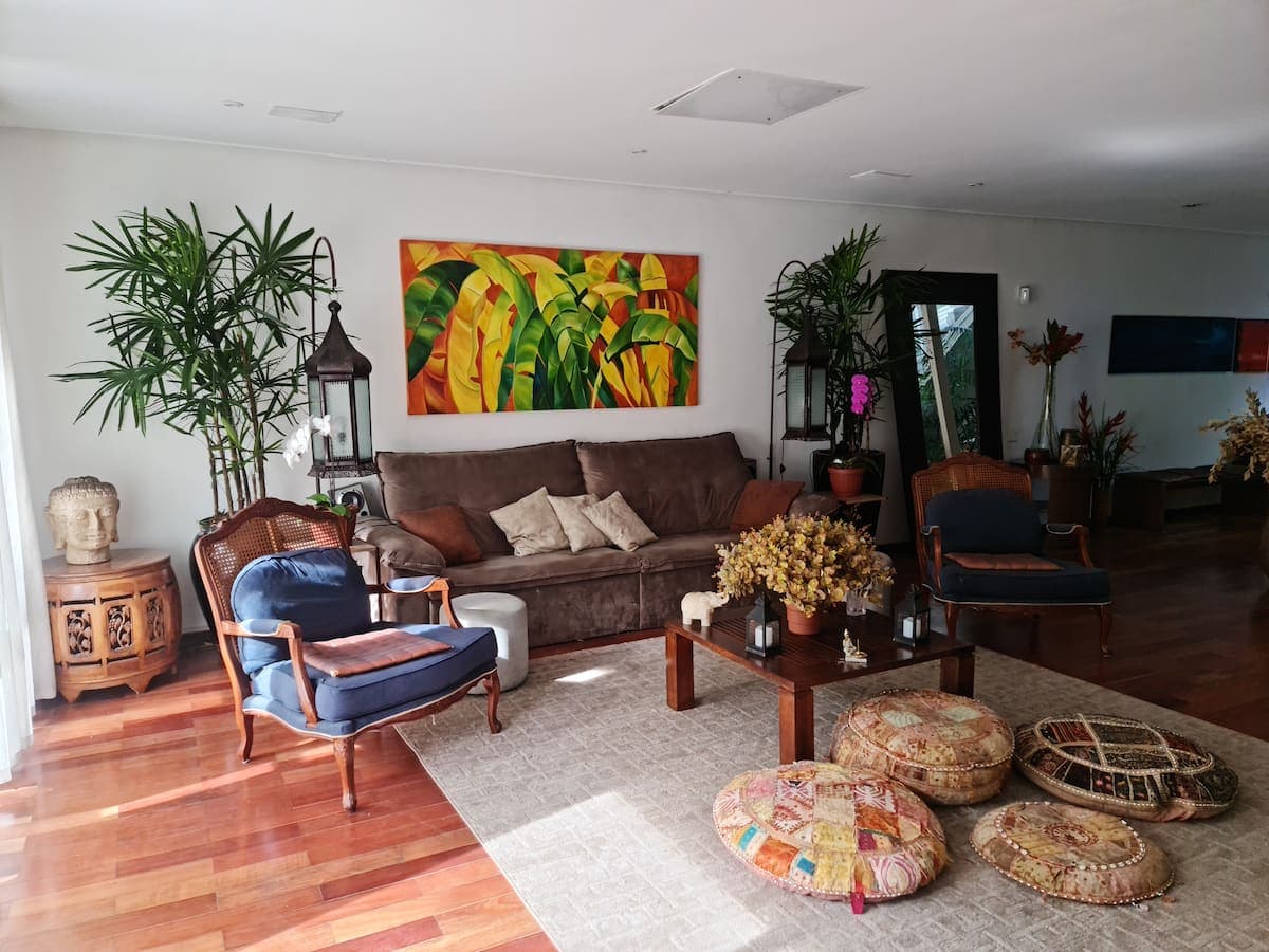 Sala de estar com sofa marrom e almofadas no tapete