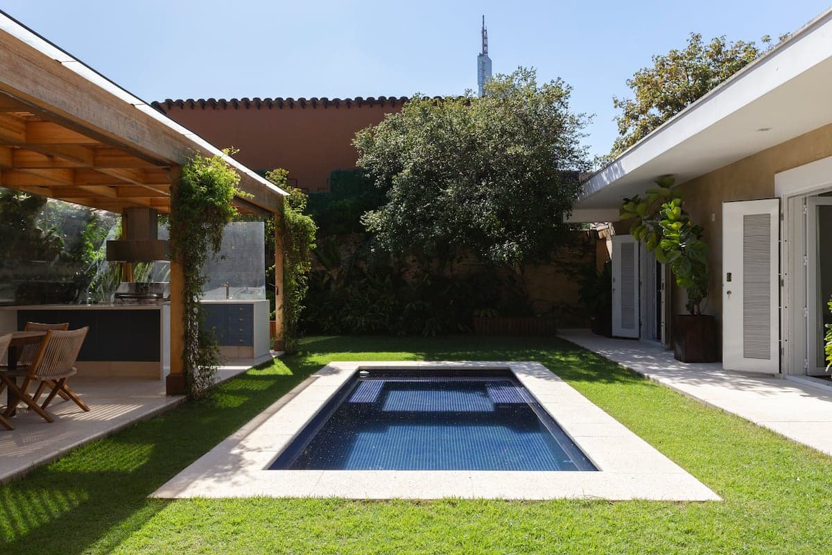 Piscina ao lado da casa, com jardim