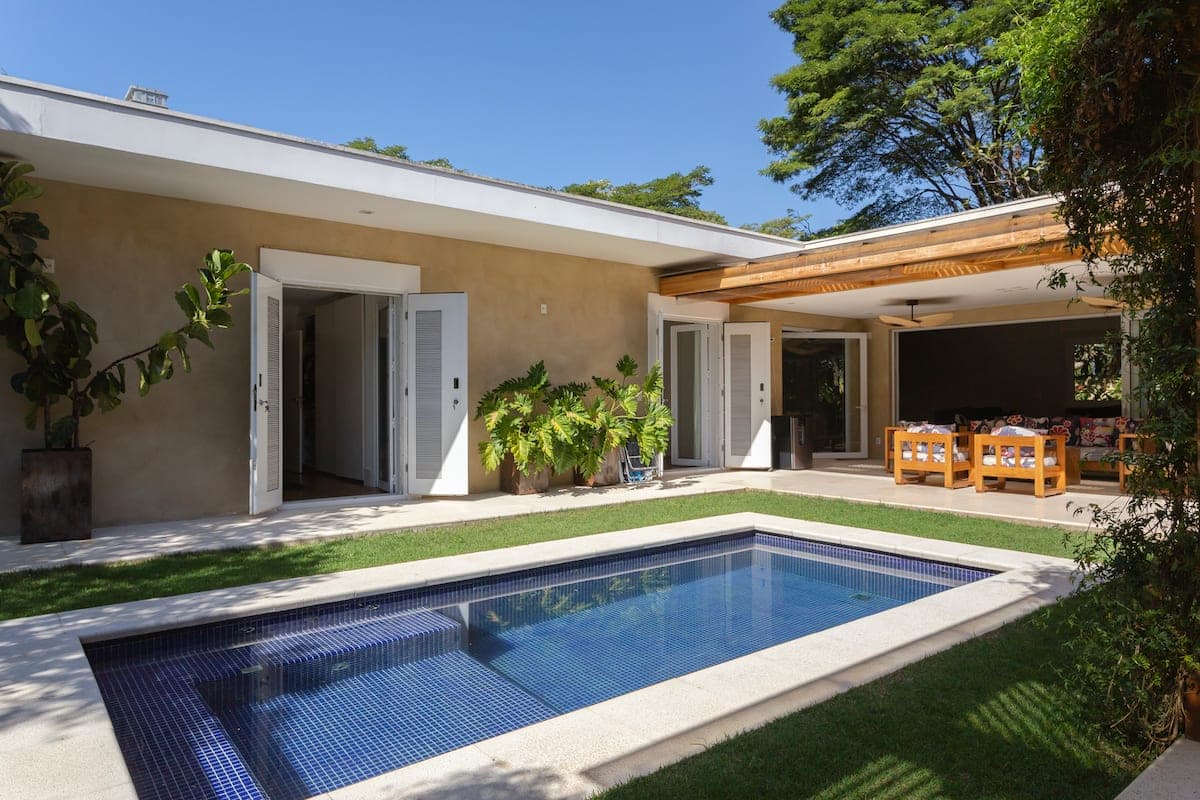 Piscina alongada com a casa ao fundo