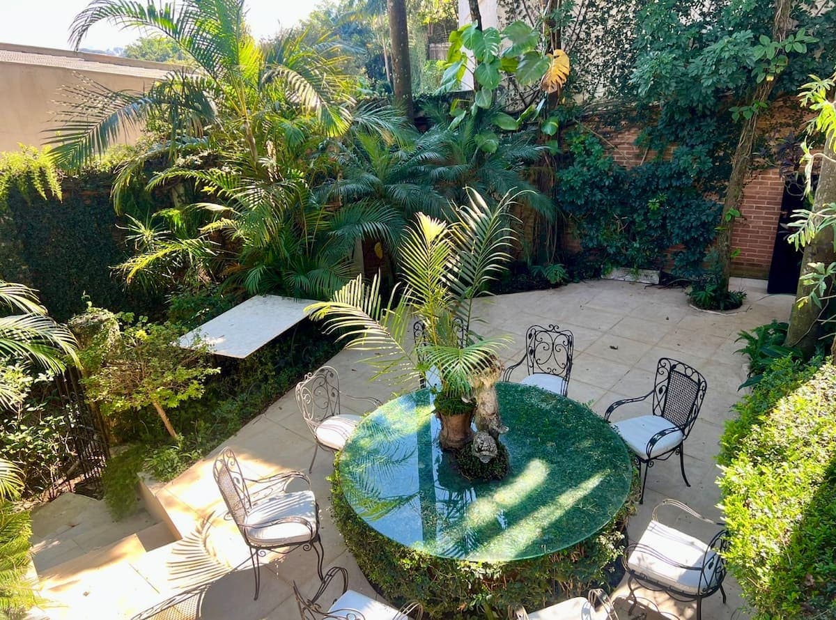 Jardim com mesa redonda sob as árvores