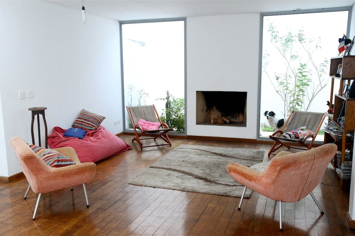 Sala ampla com lareira, poltronas e tapete