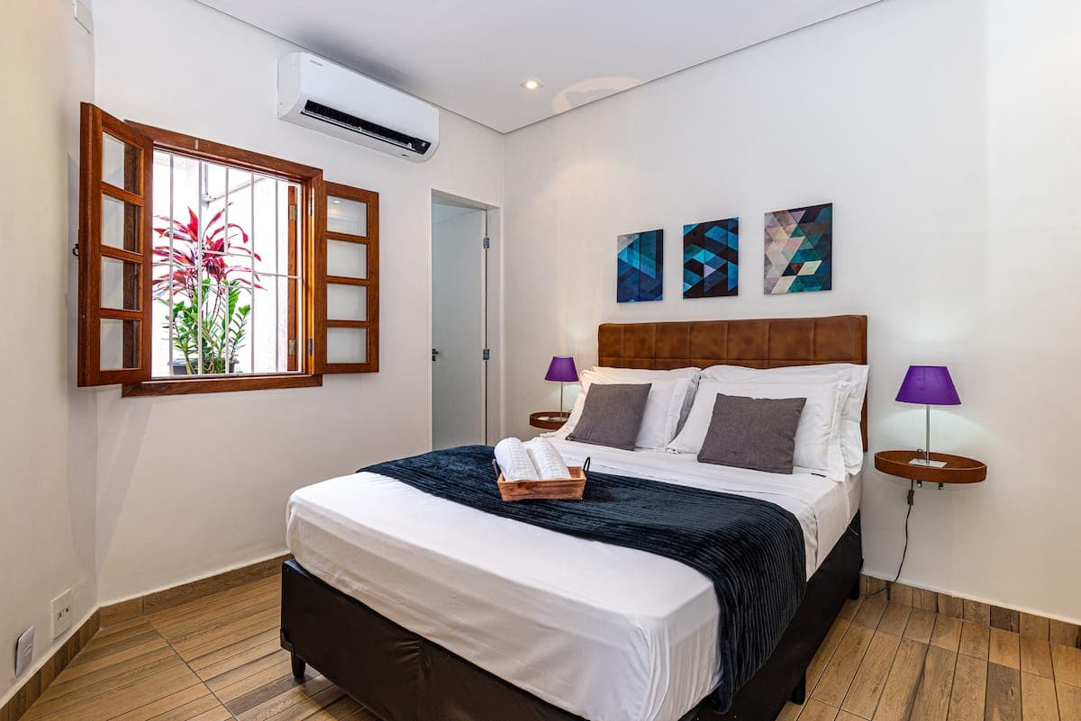 Quarto de casal com ar condicionado e janela para o jardim