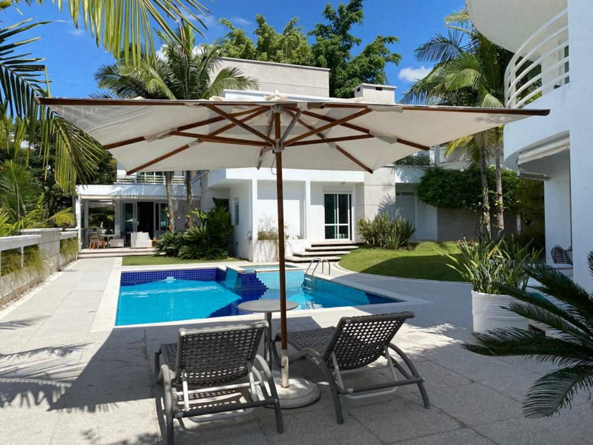 Piscina com guarda-sol e espreguiçadeiras