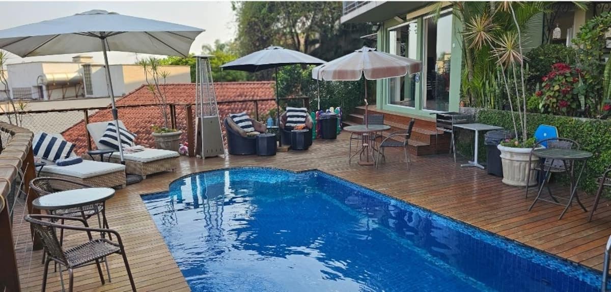Piscina com deck e mesas com guarda-sol