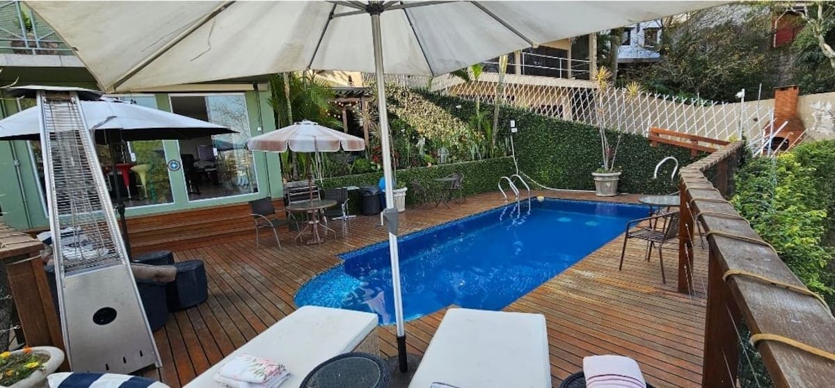 Piscina com espreguiçadeiras e guarda-sol
