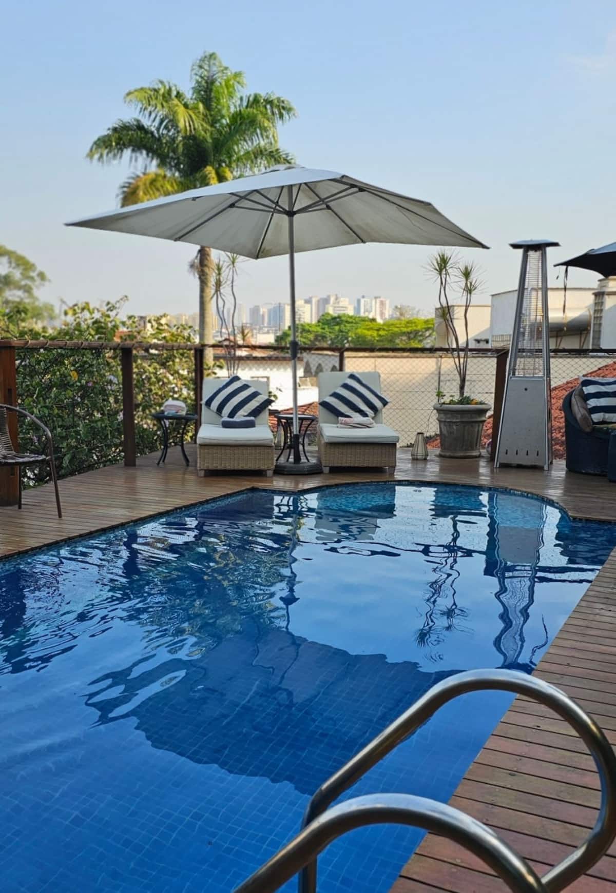 Piscina com guarda-sóis e espreguiçadeiras