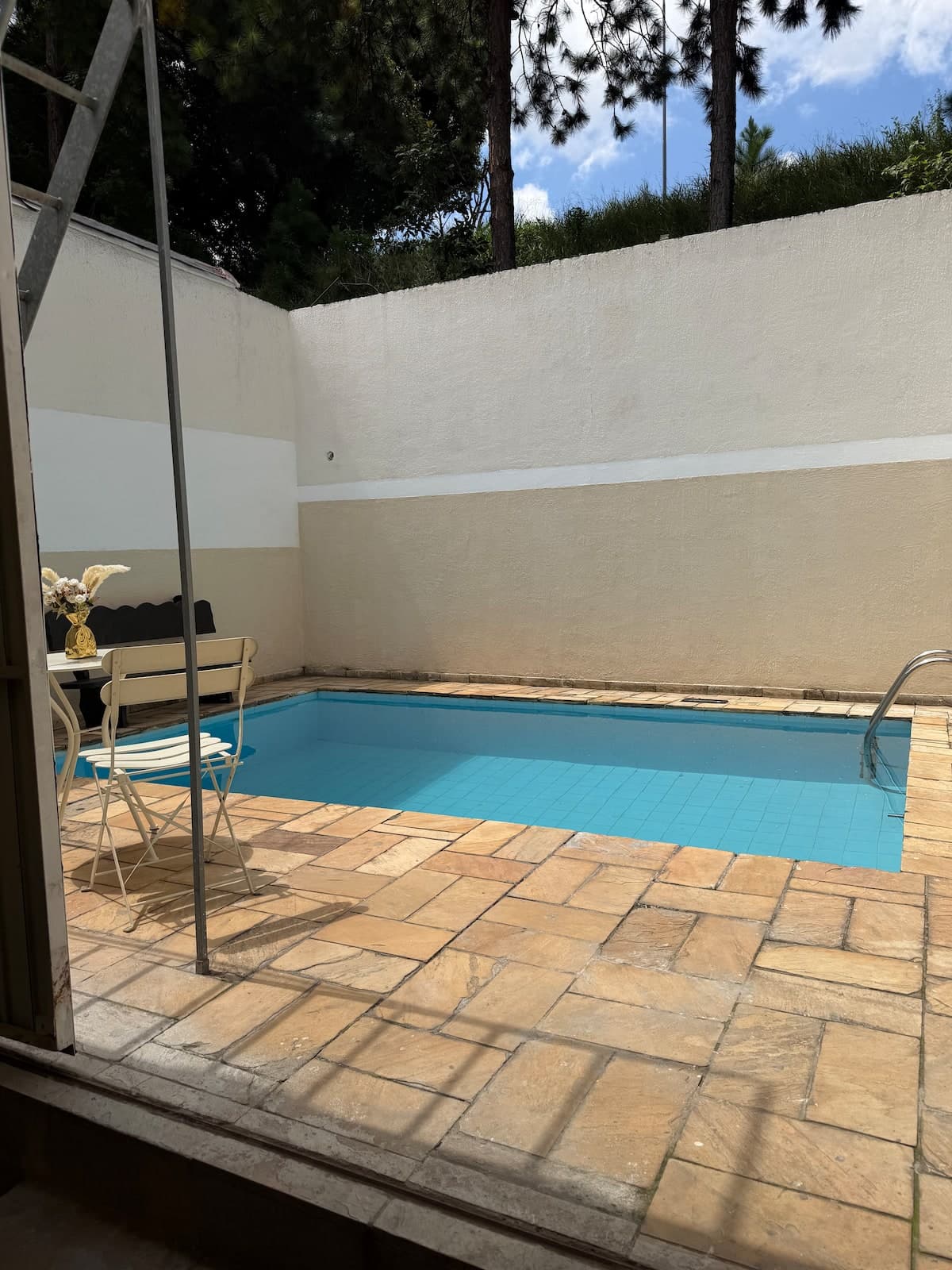 Piscina vista da porta de vidro, com deck ao redor