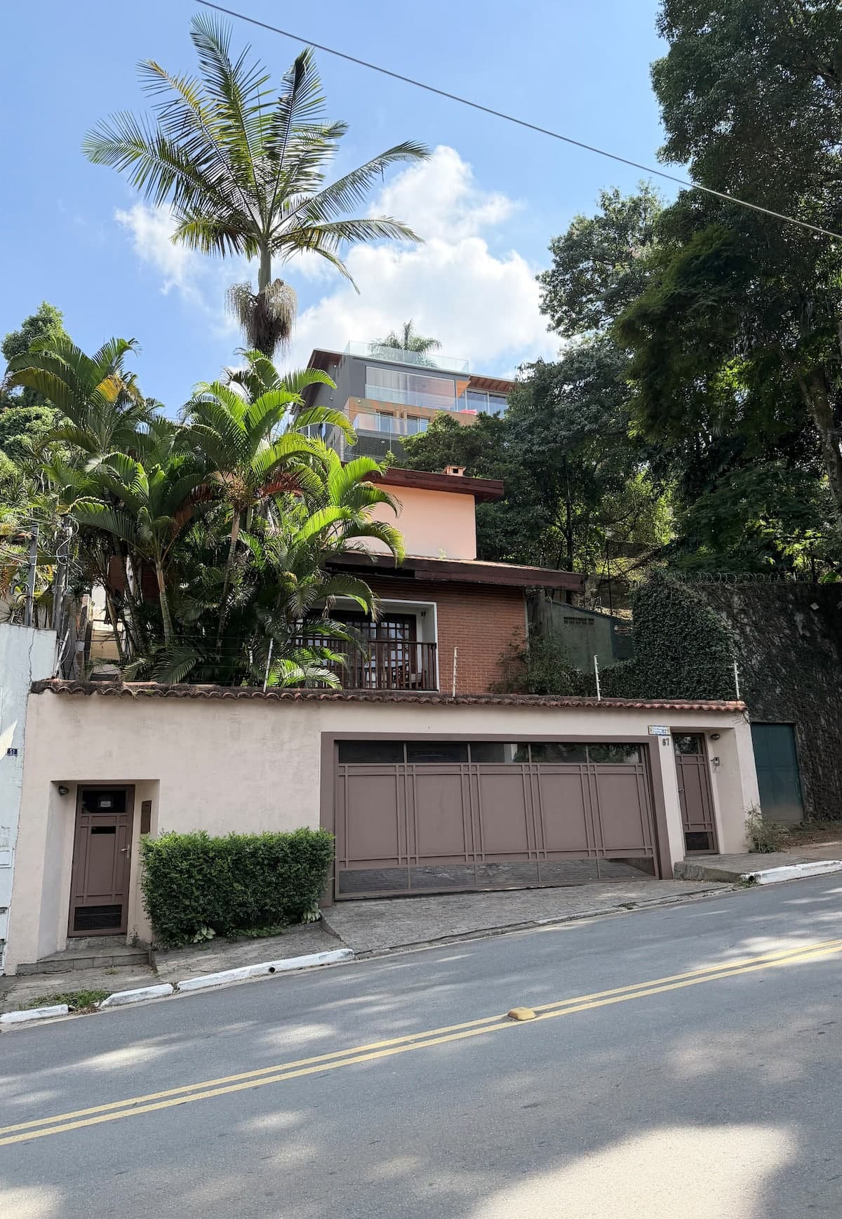 Entrada da casa com muro e vegetação