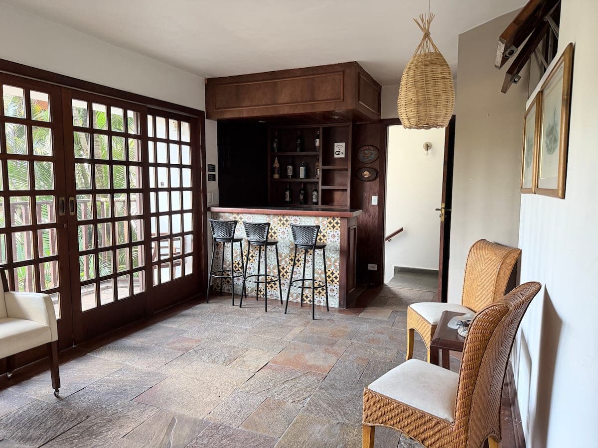 Sala com bar de madeira e banquetas