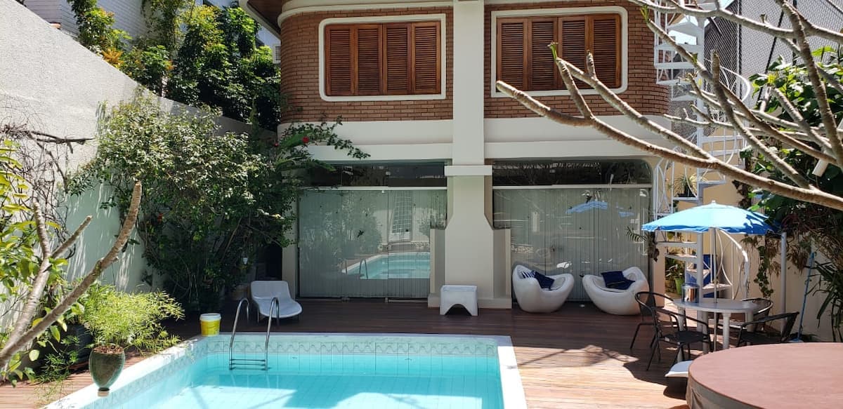 Piscina com área de estar coberta ao lado