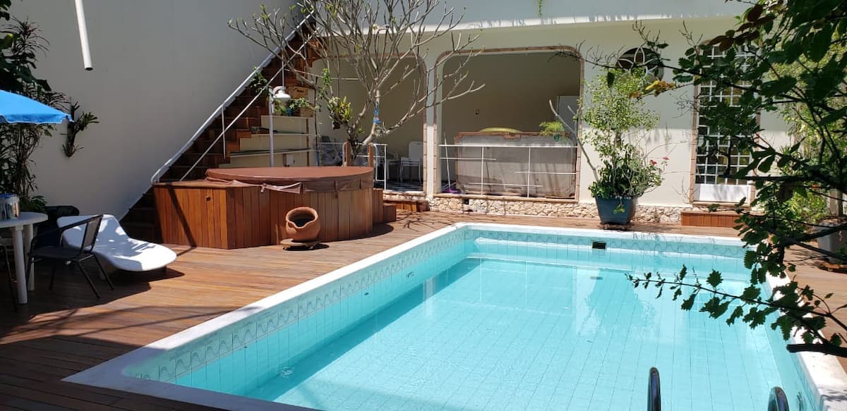 Piscina com deck de madeira e ofurô