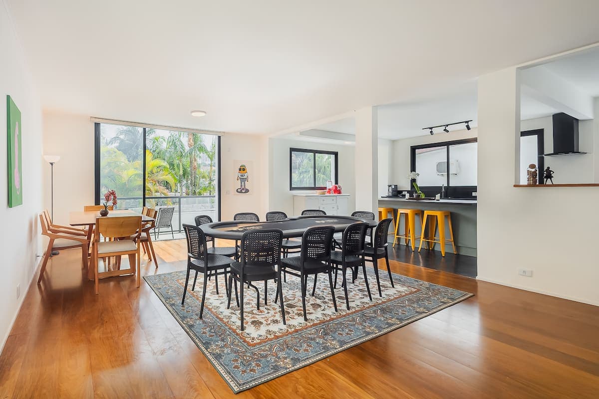 Sala de jantar com mesa grande e cozinha ao fundo