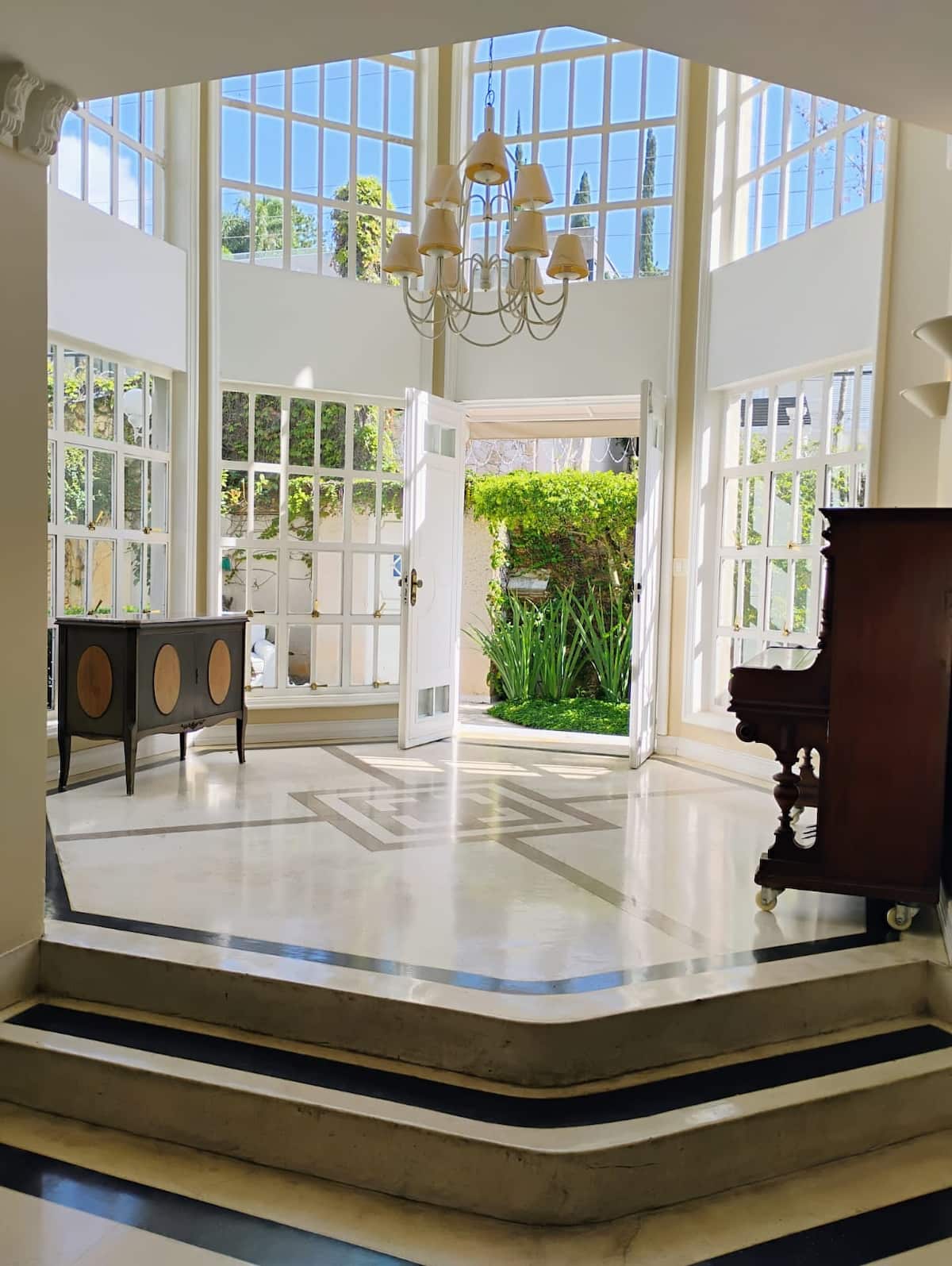 Salão com piano e portas para o jardim