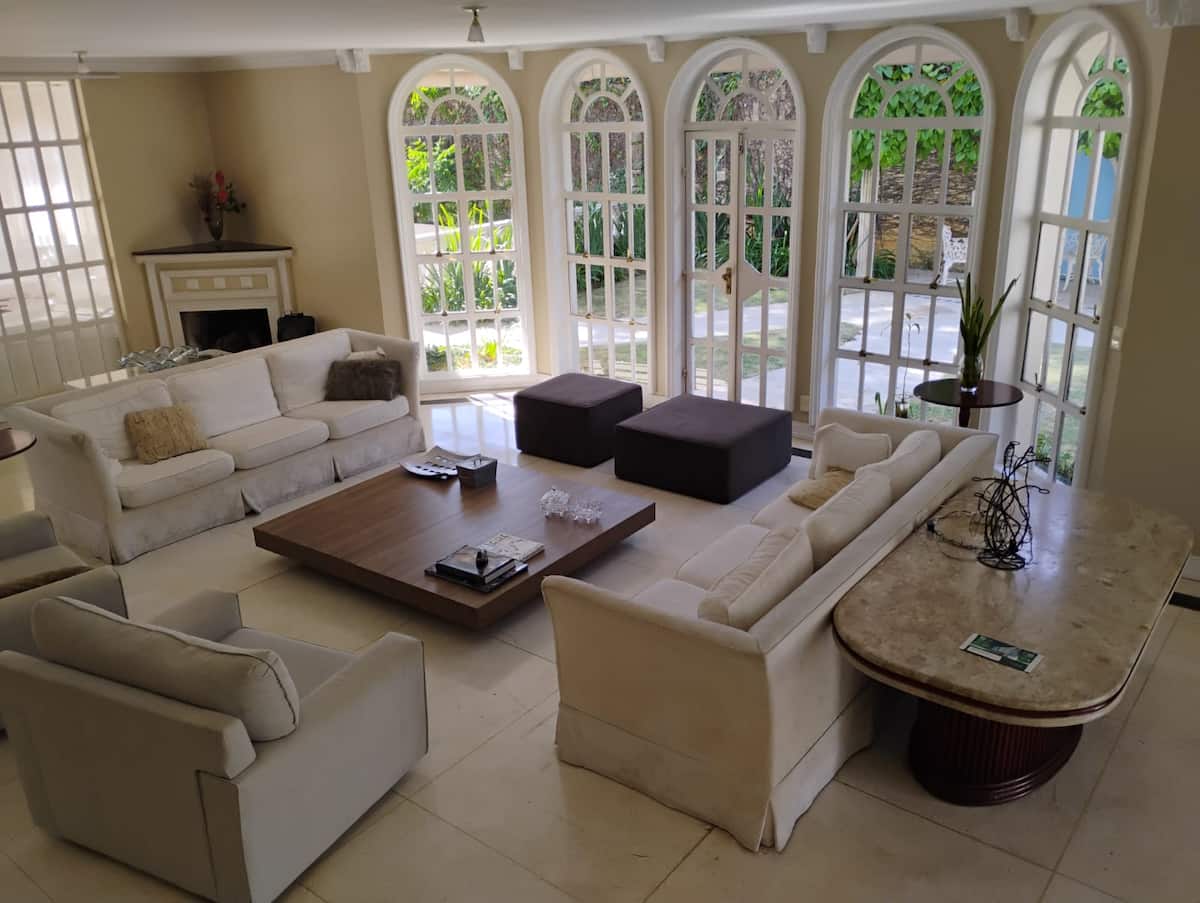 Sala de estar com sofás e janelas altas