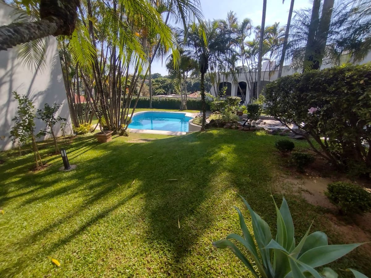 Jardim gramado com a piscina ao fundo