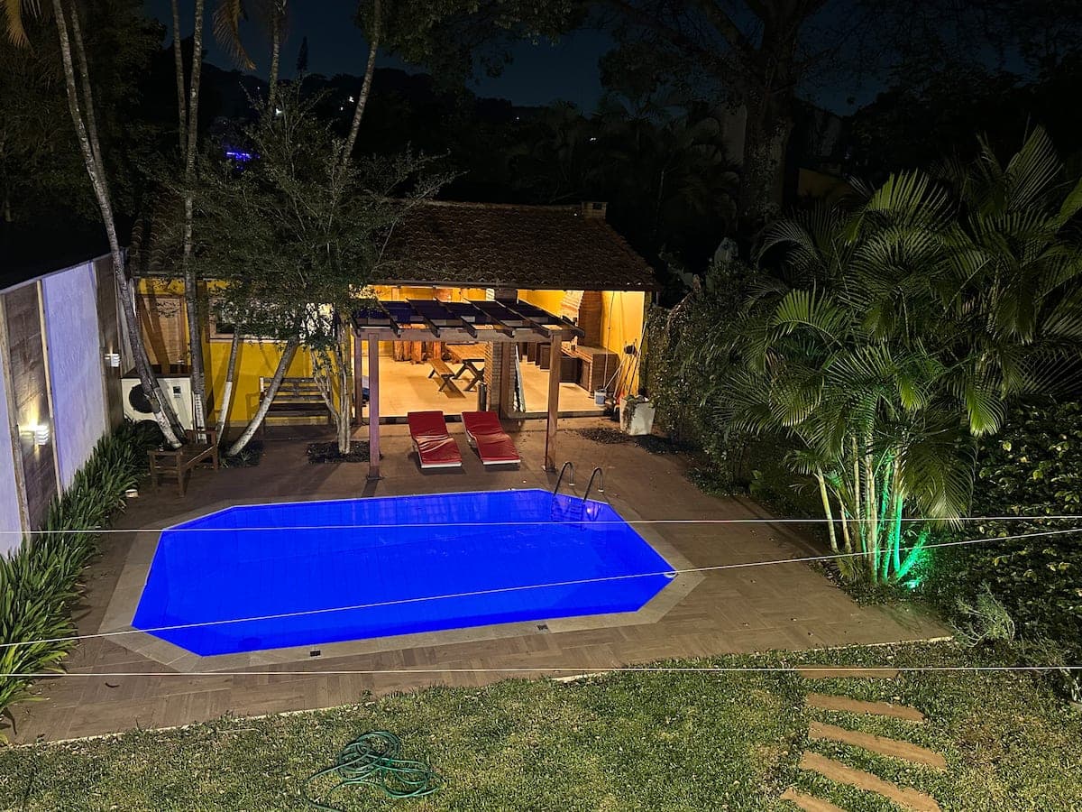 Quintal com piscina coberta e árvores