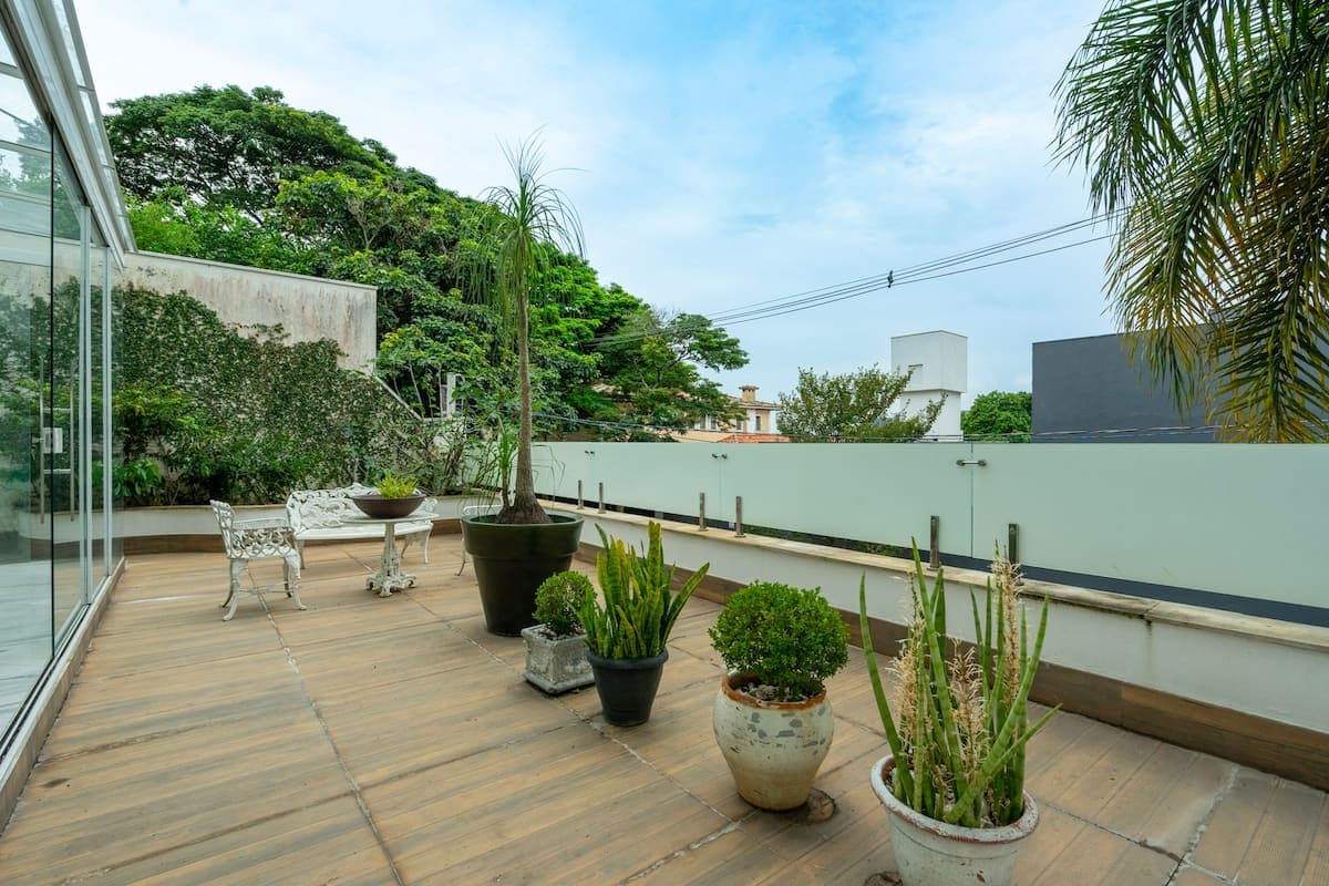Terraço com vasos de plantas e vista para o bairro