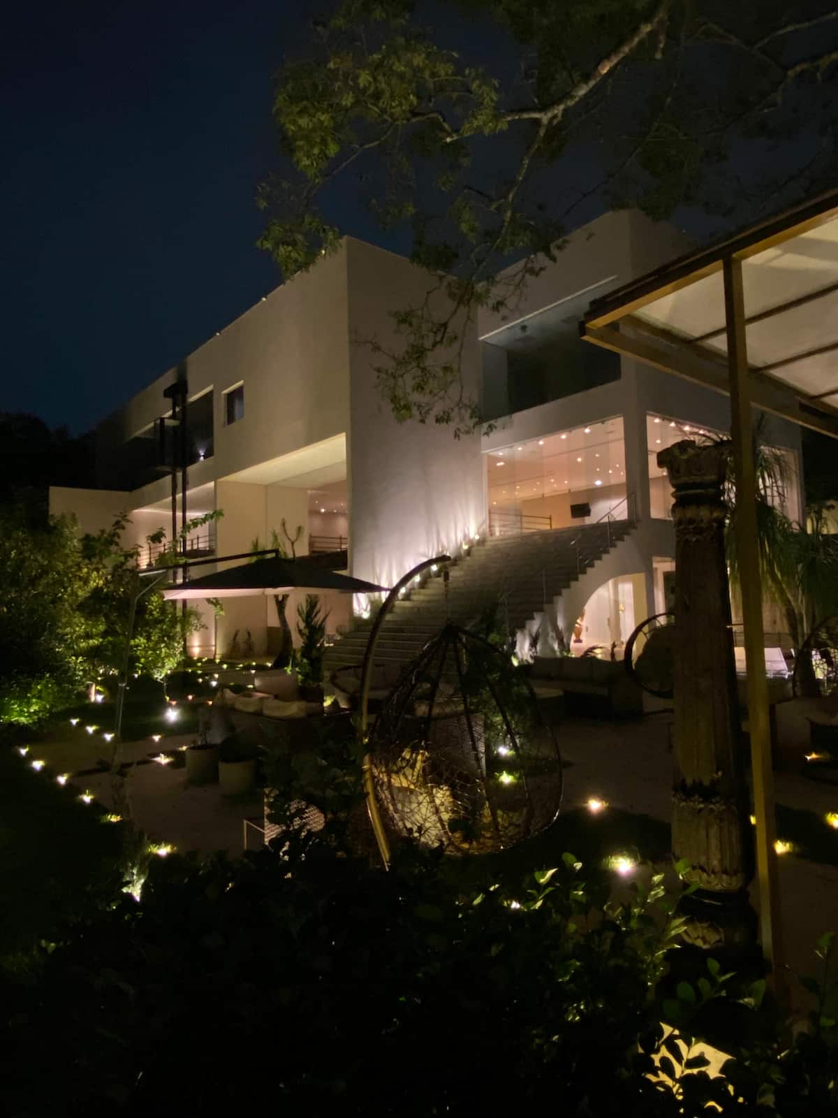 Fachada iluminada com jardim à noite