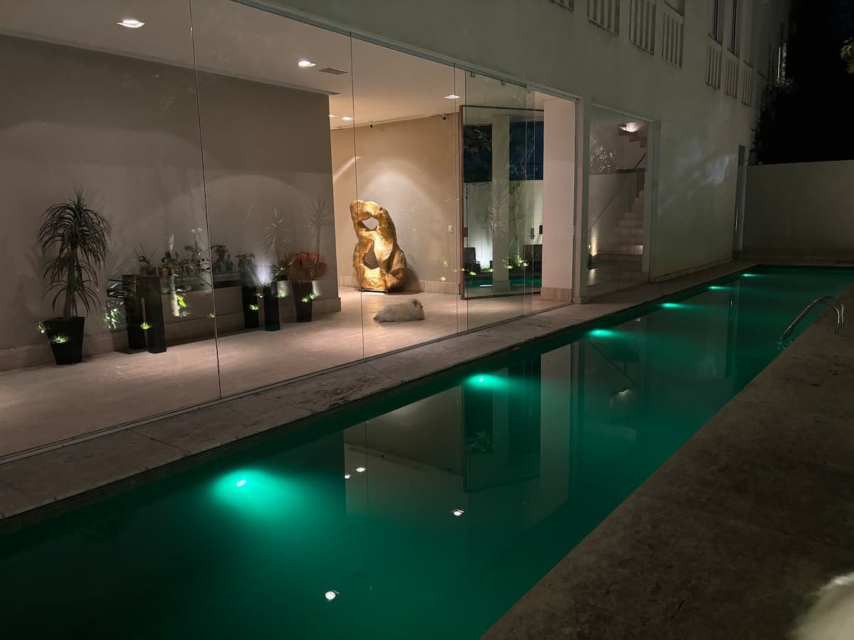Piscina alongada iluminada à noite