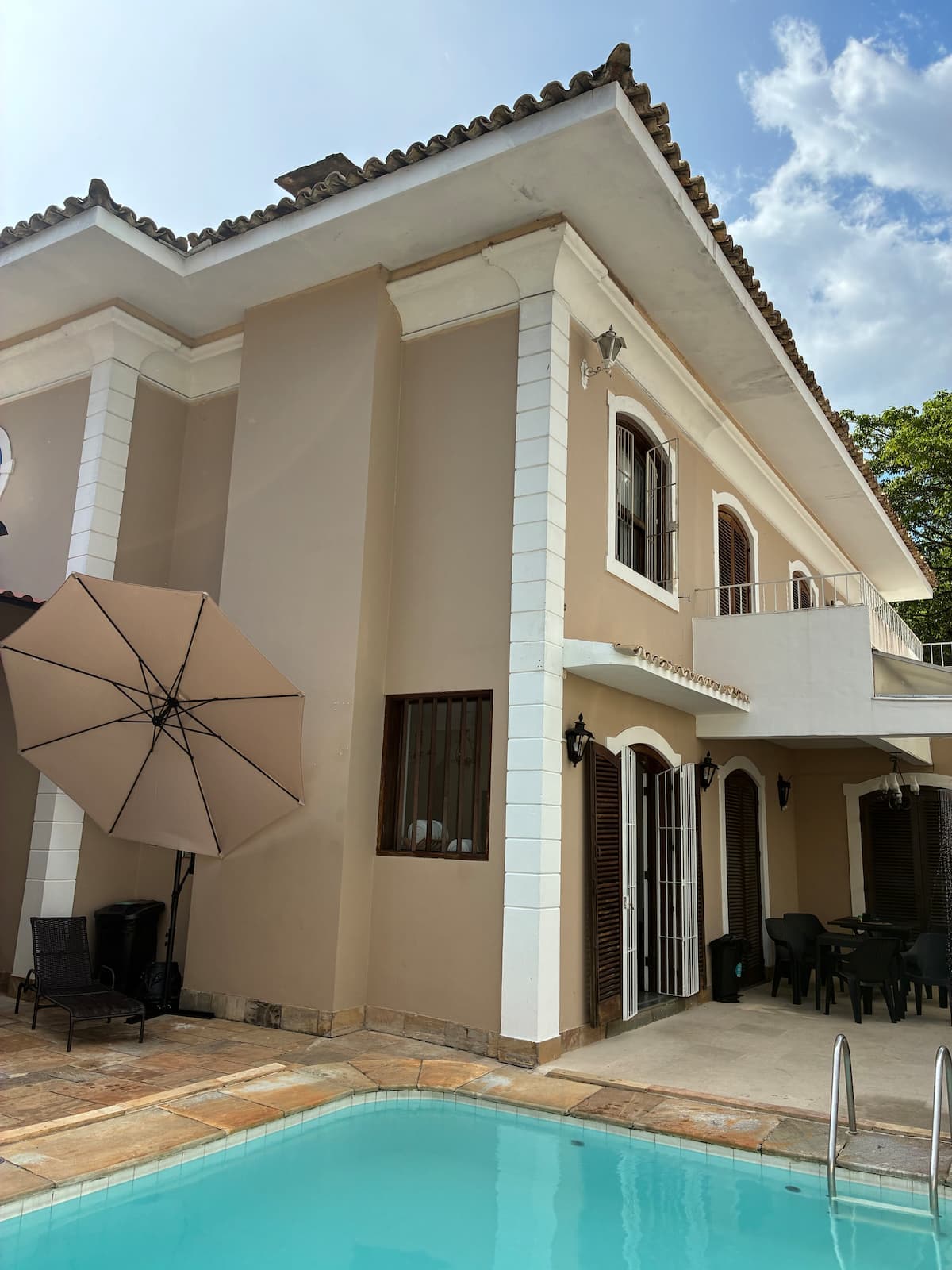 Fachada da casa com guarda-sol no jardim