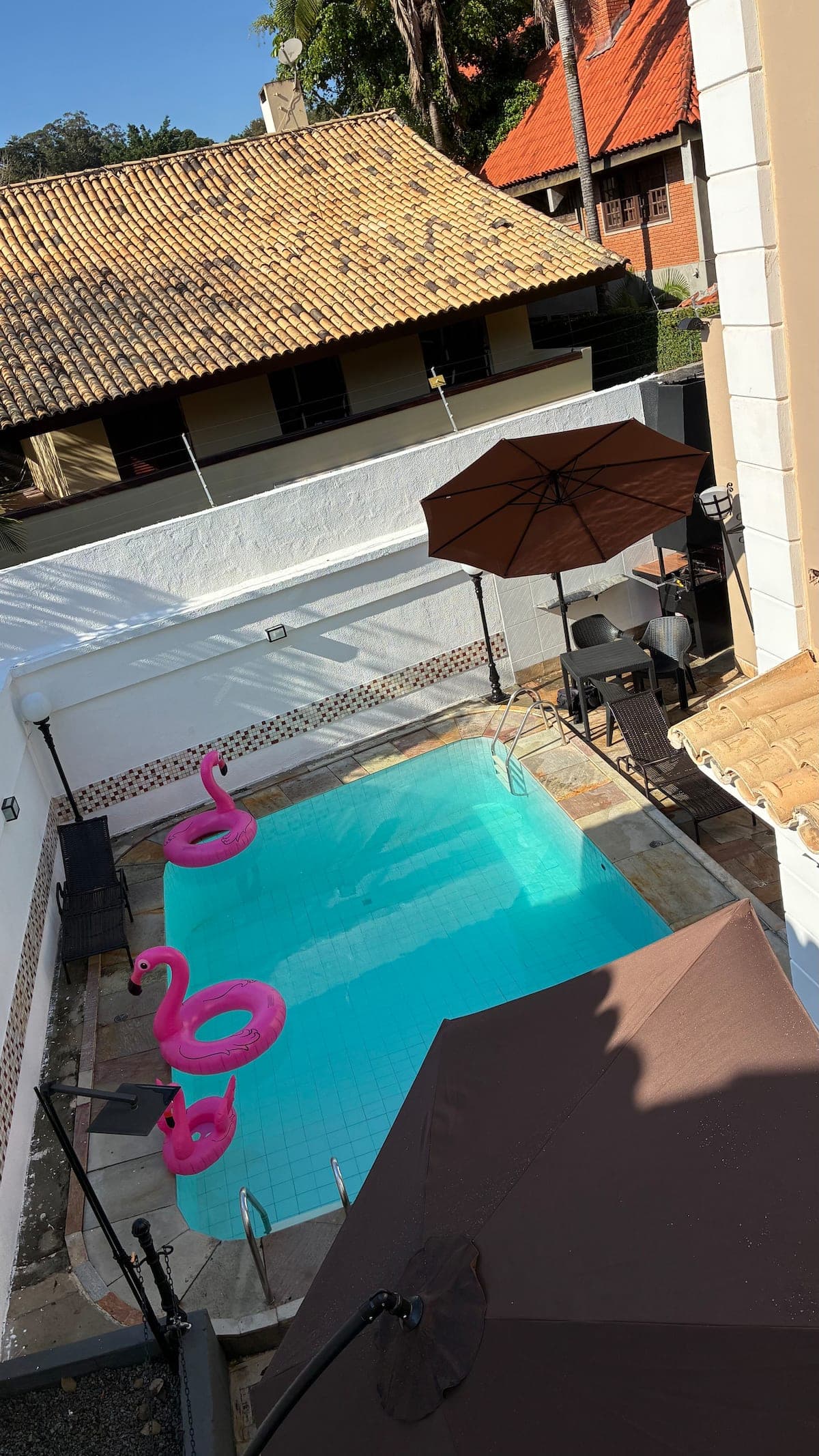 Piscina com guarda-sol e boias