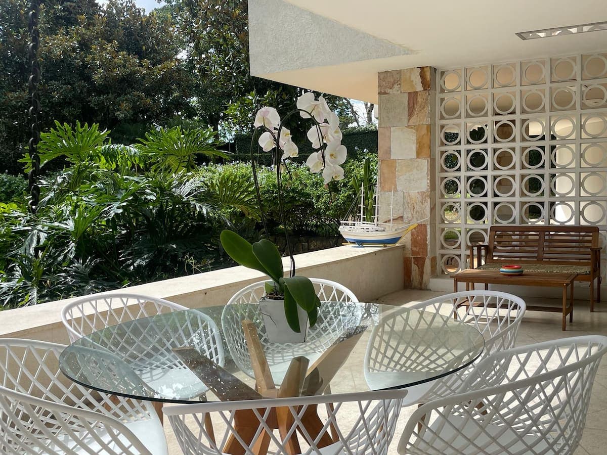 Mesa de vidro na varanda com vista para o verde