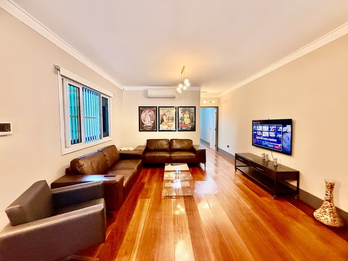 Sala de estar com sofa de couro e TV