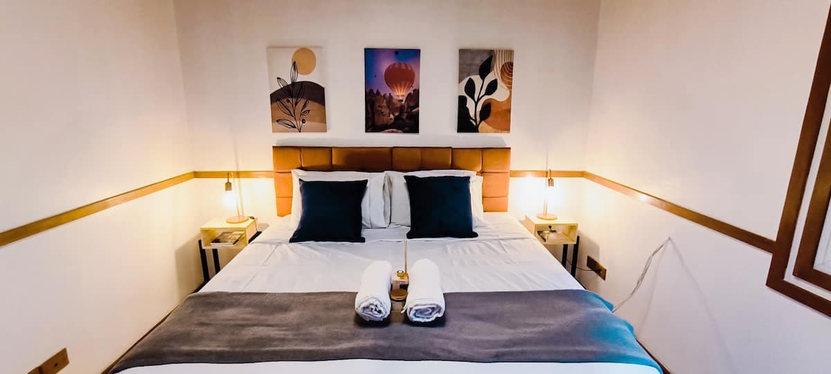 Quarto de casal com quadros e luminarias de cabeceira
