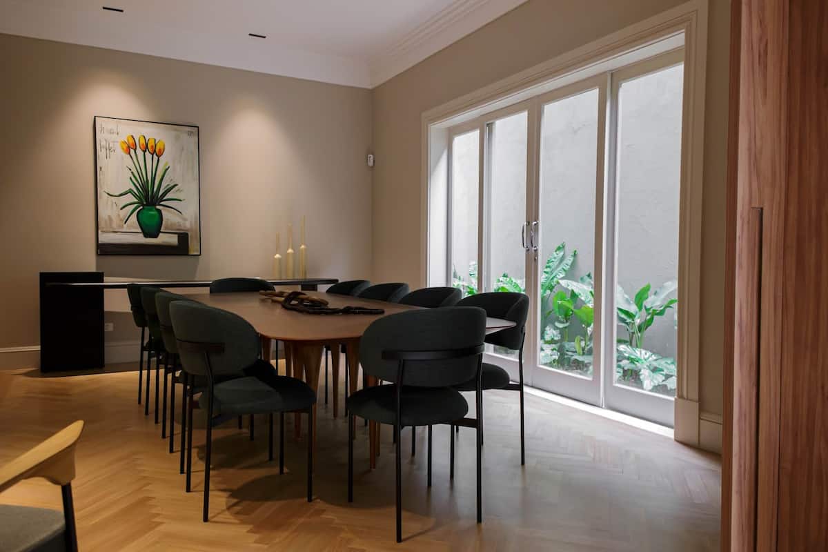 Sala de jantar com mesa comprida e portas para o jardim